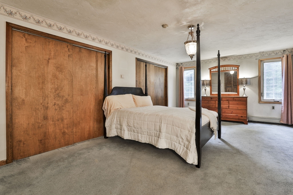 47 Sugar Road Bolton, MA 01740 - Photo 35 of 42 a spacious bedroom with a bed closet and wooden floor