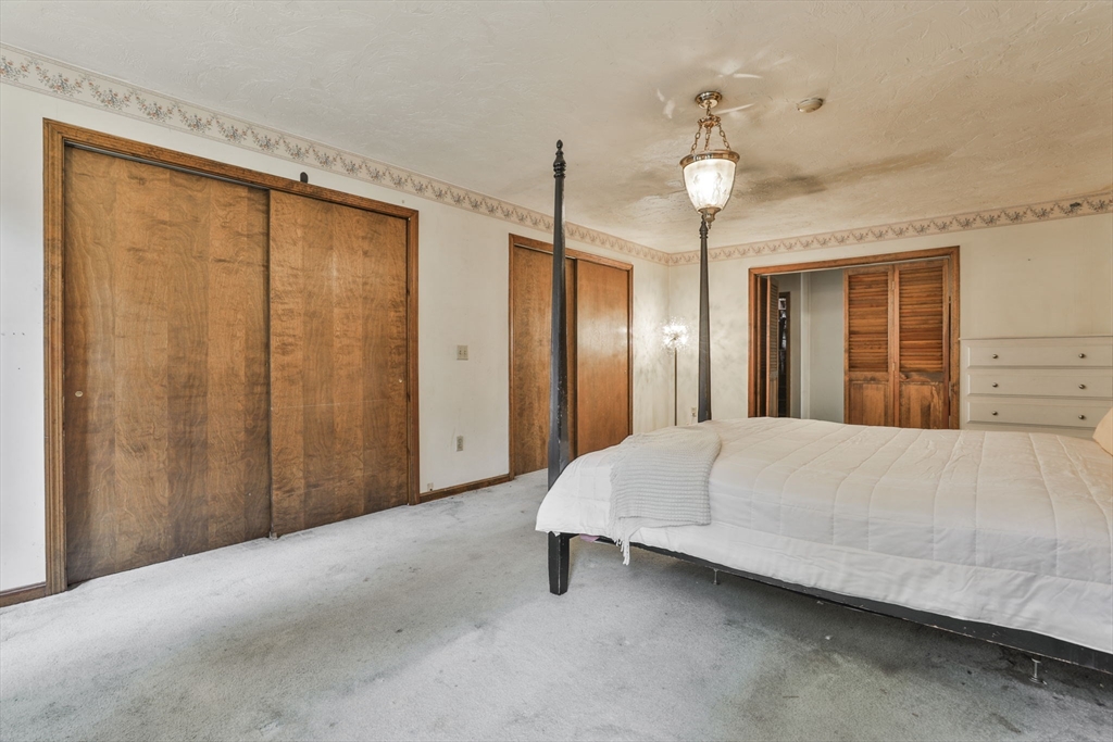 47 Sugar Road Bolton, MA 01740 - Photo 37 of 42 a bed room with a bed and a chandelier