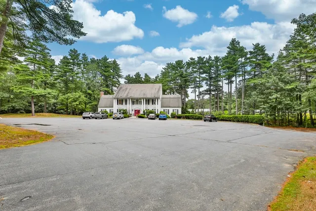 a view of swimming pool with outdoor seating and trees in the background