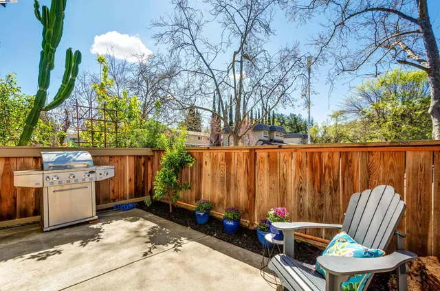a backyard of a house with barbeque oven and outdoor seating
