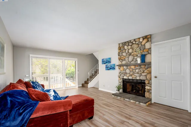 a living room with furniture a fireplace and a large window