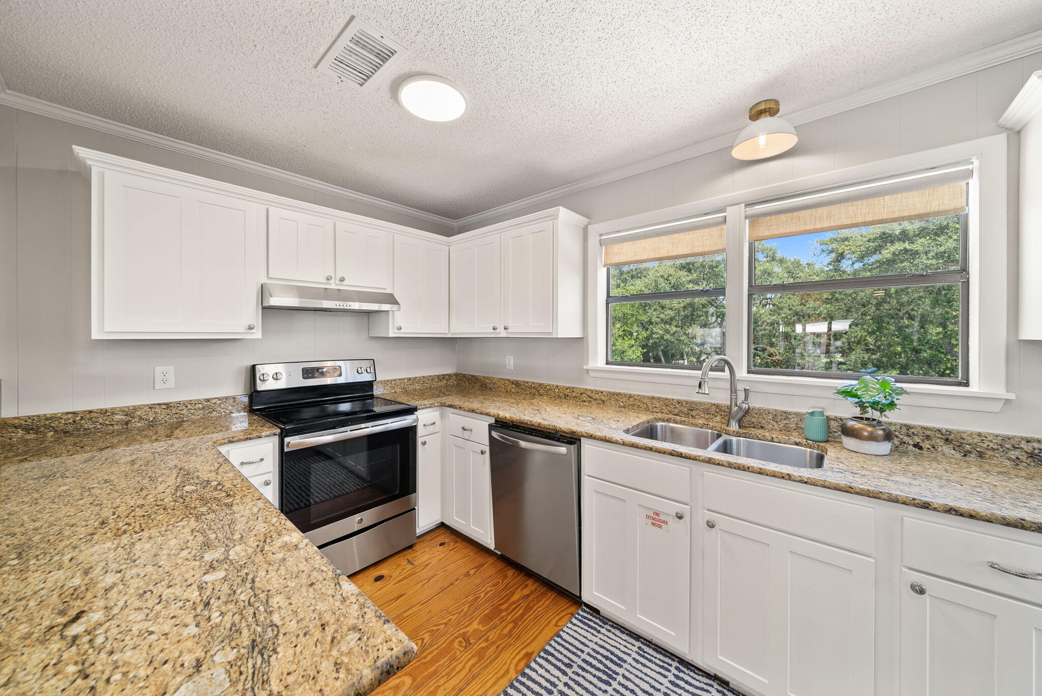 8009 East County Highway 30A Inlet Beach, FL 32461 - Photo 36 of 56 a kitchen with granite countertop a sink stainless steel appliances and white cabinets