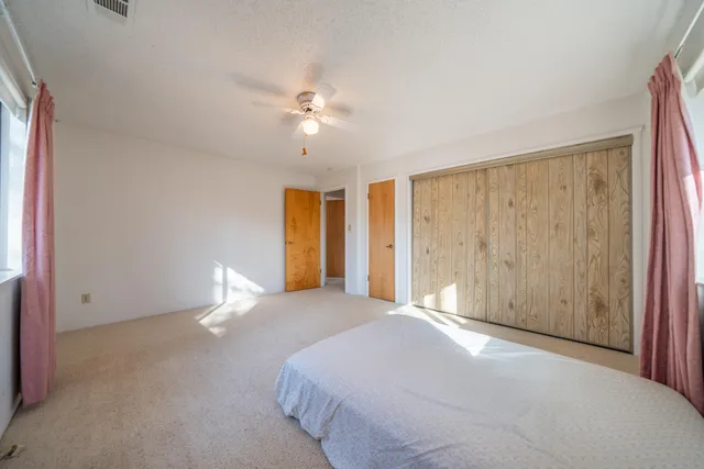 a bedroom with a large bed and a chandelier