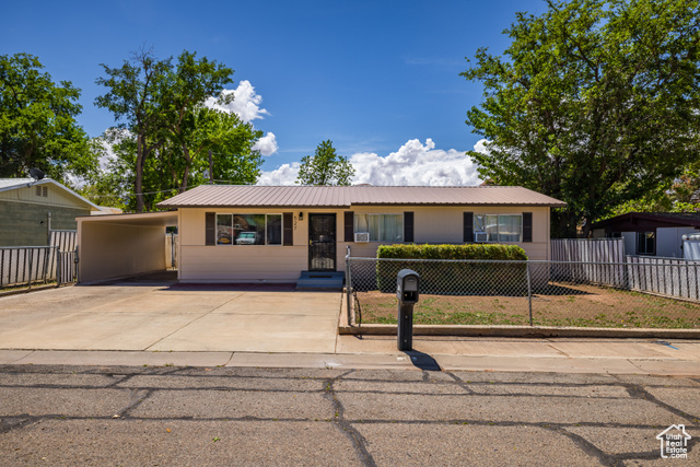 527 Palisade Drive Moab, UT 84532 - Photo 24 of 51 Ranch-style house featuring a fenced front yard, metal roof, driveway, and a carport