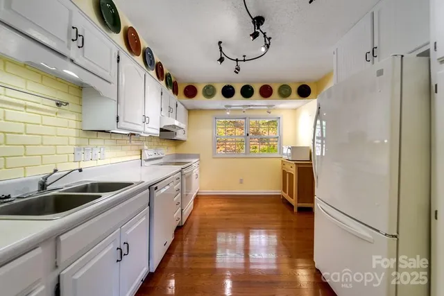 a kitchen with stainless steel appliances granite countertop a sink a refrigerator and a stove