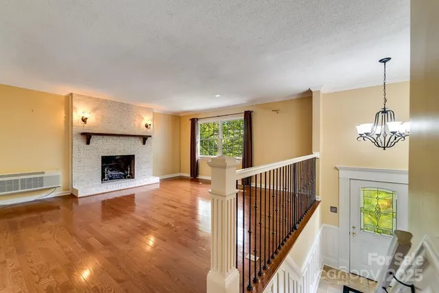 a view of an empty room with a fireplace and a window