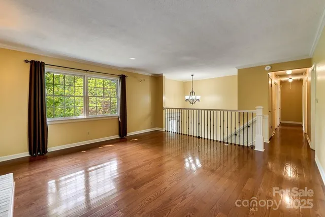 a view of a room with wooden floor and windows