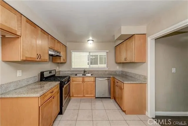 a kitchen with stainless steel appliances granite countertop a stove top oven a sink a counter top space and cabinets