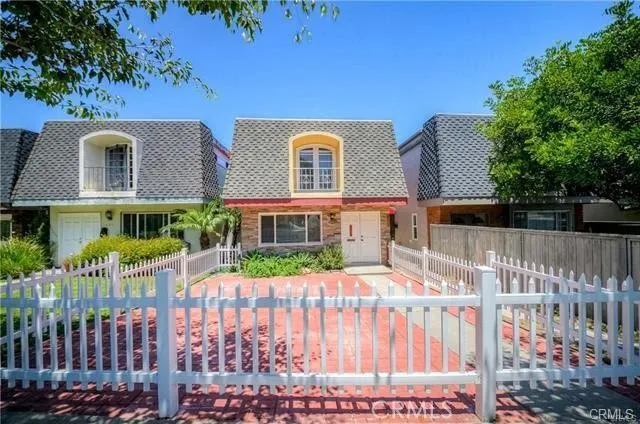 a view of a brick house with a wooden fence