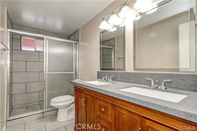 a bathroom with a granite countertop sink mirror and toilet