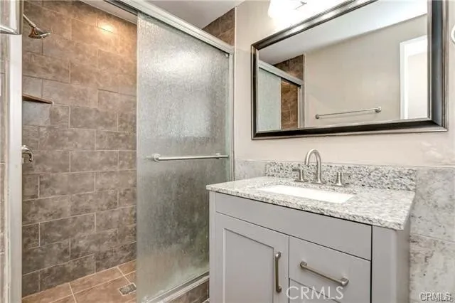 a bathroom with a granite countertop sink and a mirror