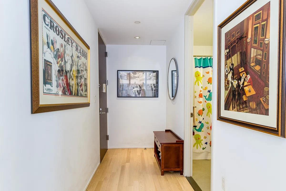 110 3rd Avenue, Unit 9A Manhattan, NY 10003 - Photo 4 of 13 a view of a hallway with painting on the wall and a large window