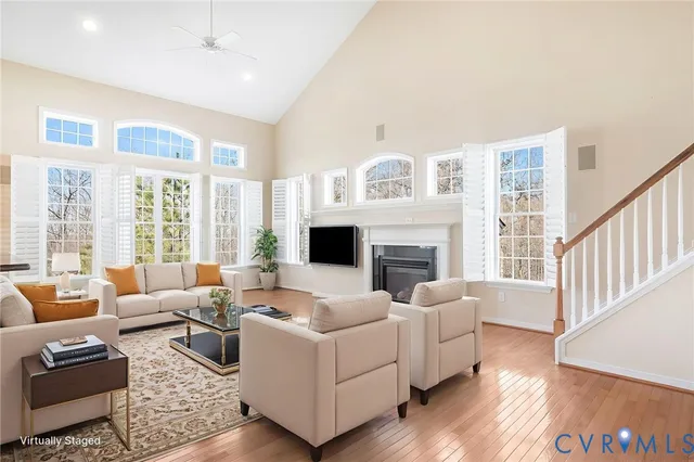 a living room with furniture fireplace and a large window