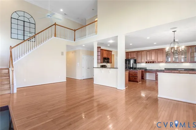 a kitchen with stainless steel appliances granite countertop a stove top oven a sink dishwasher a dining table and chairs with wooden floor