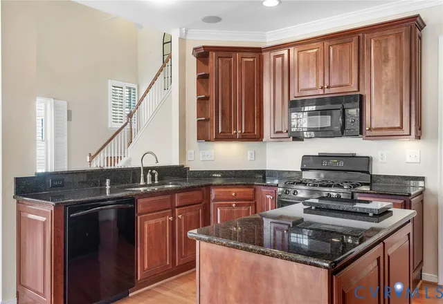 a kitchen with granite countertop a sink stove and cabinets