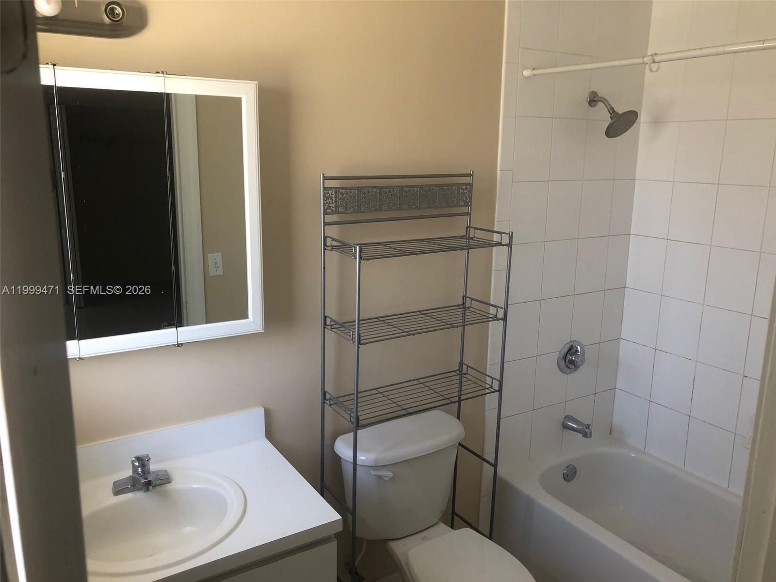 12787 Southwest 257th Street, Unit 12787 Homestead, FL 33032 - Photo 5 of 5 a bathroom with a sink toilet and shower