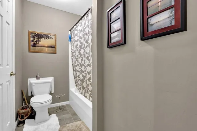 a white toilet sitting next to a white wall