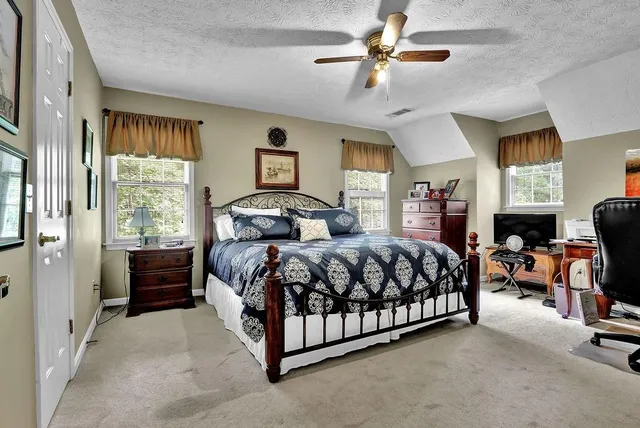 a bedroom with a bed chandelier and a window