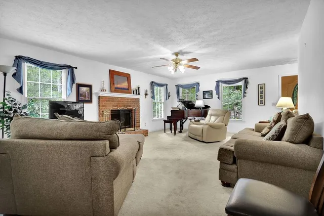 a living room with furniture fireplace and a window