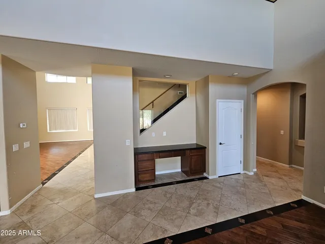 a view of an empty room with wooden floor and a fireplace