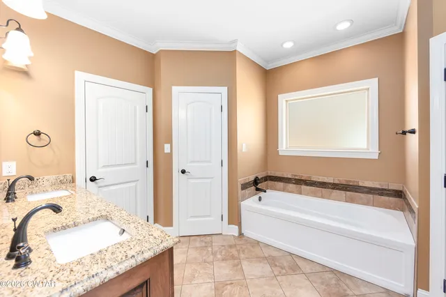 a spacious bathroom with a granite countertop tub sink and mirror