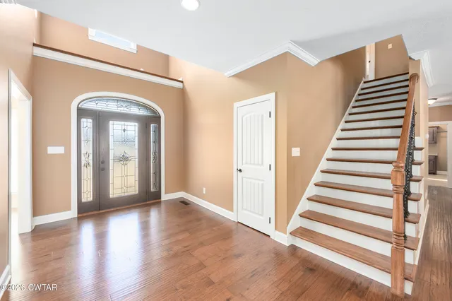 a view of a hallway with entryway and wooden floor