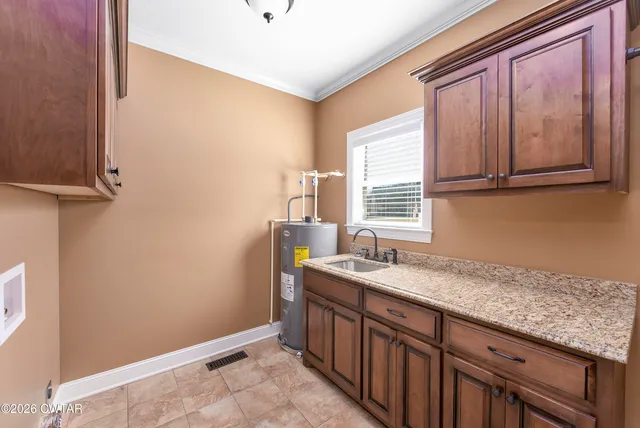 a utility room with granite countertop cabinets washer and dryer