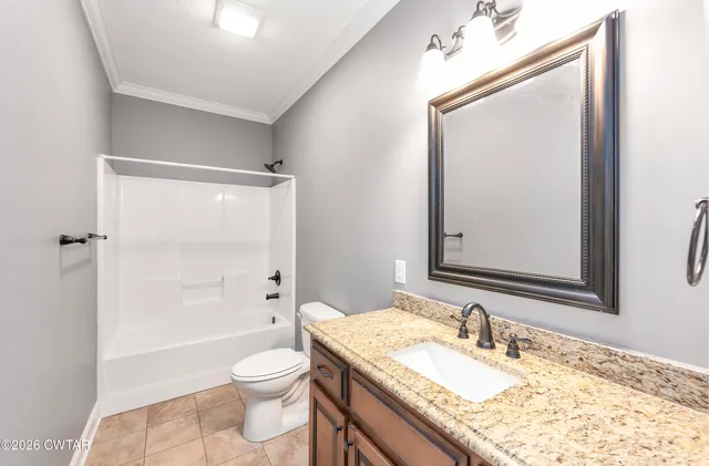 a bathroom with a granite countertop sink toilet a large mirror a shower and a bathtub