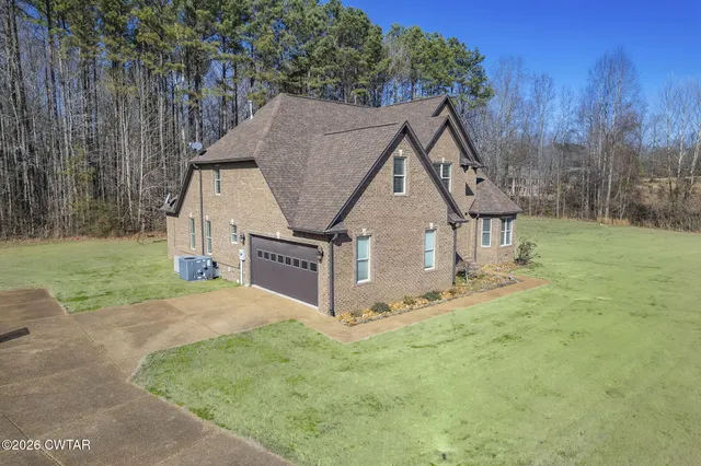 a view of a house with backyard and trees
