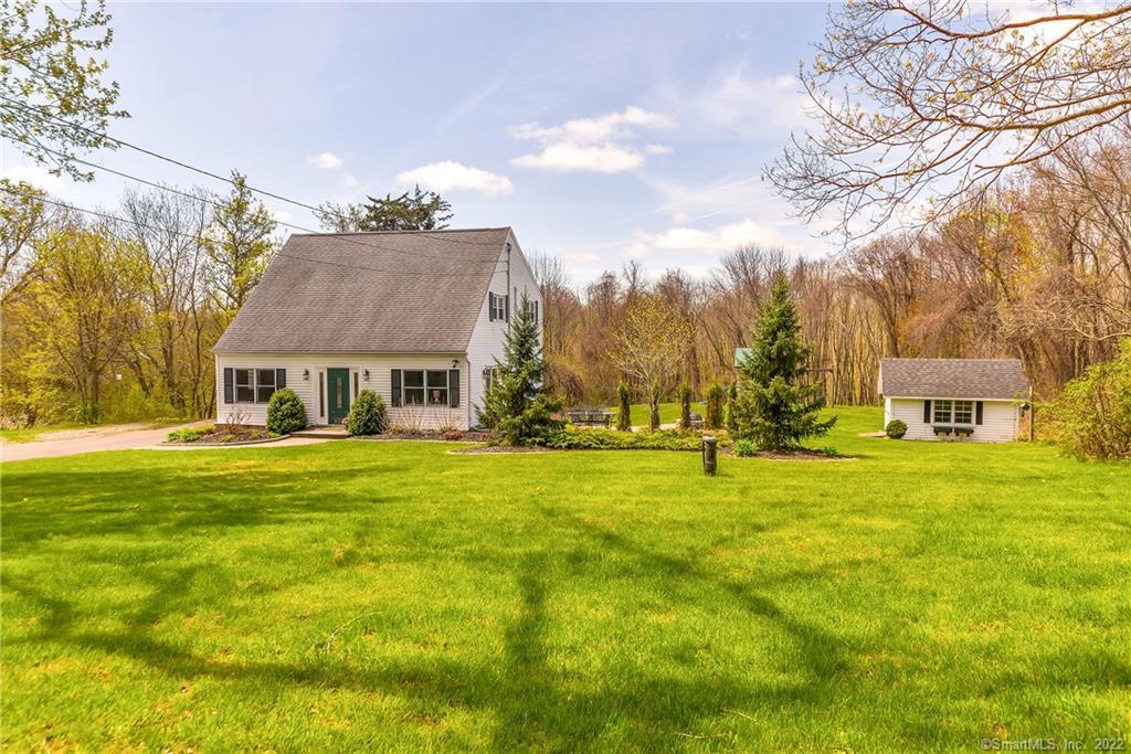 a view of a big house with a big yard and large trees