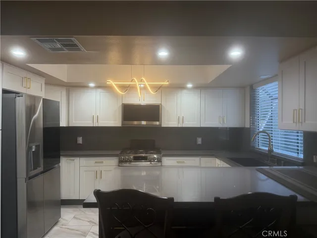 a kitchen with kitchen island a sink stainless steel appliances and cabinets