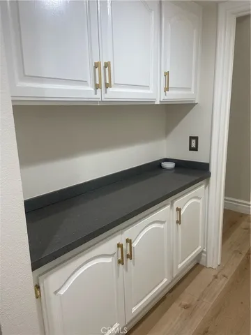 an empty room with wooden floor and fireplace