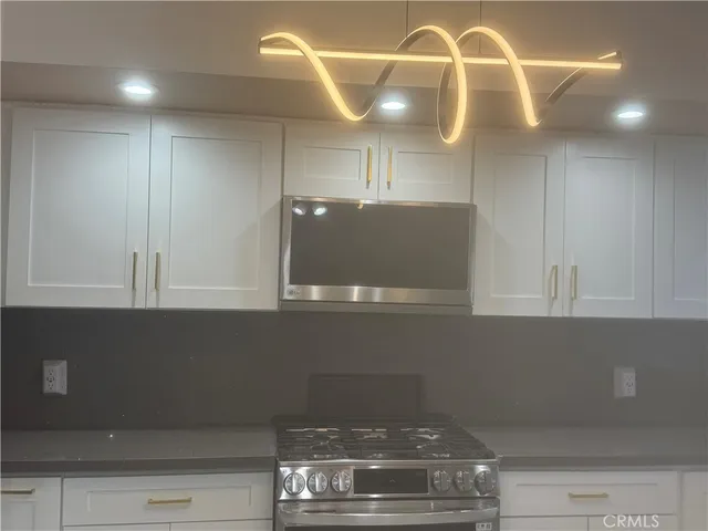 a kitchen with stainless steel appliances granite countertop a refrigerator sink and stove