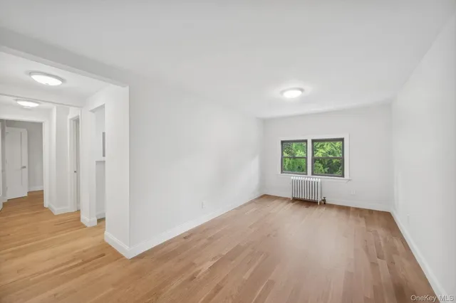 a view of a room with wooden floor and a window