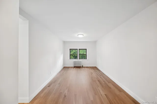 a view of a room with wooden floor and white walls