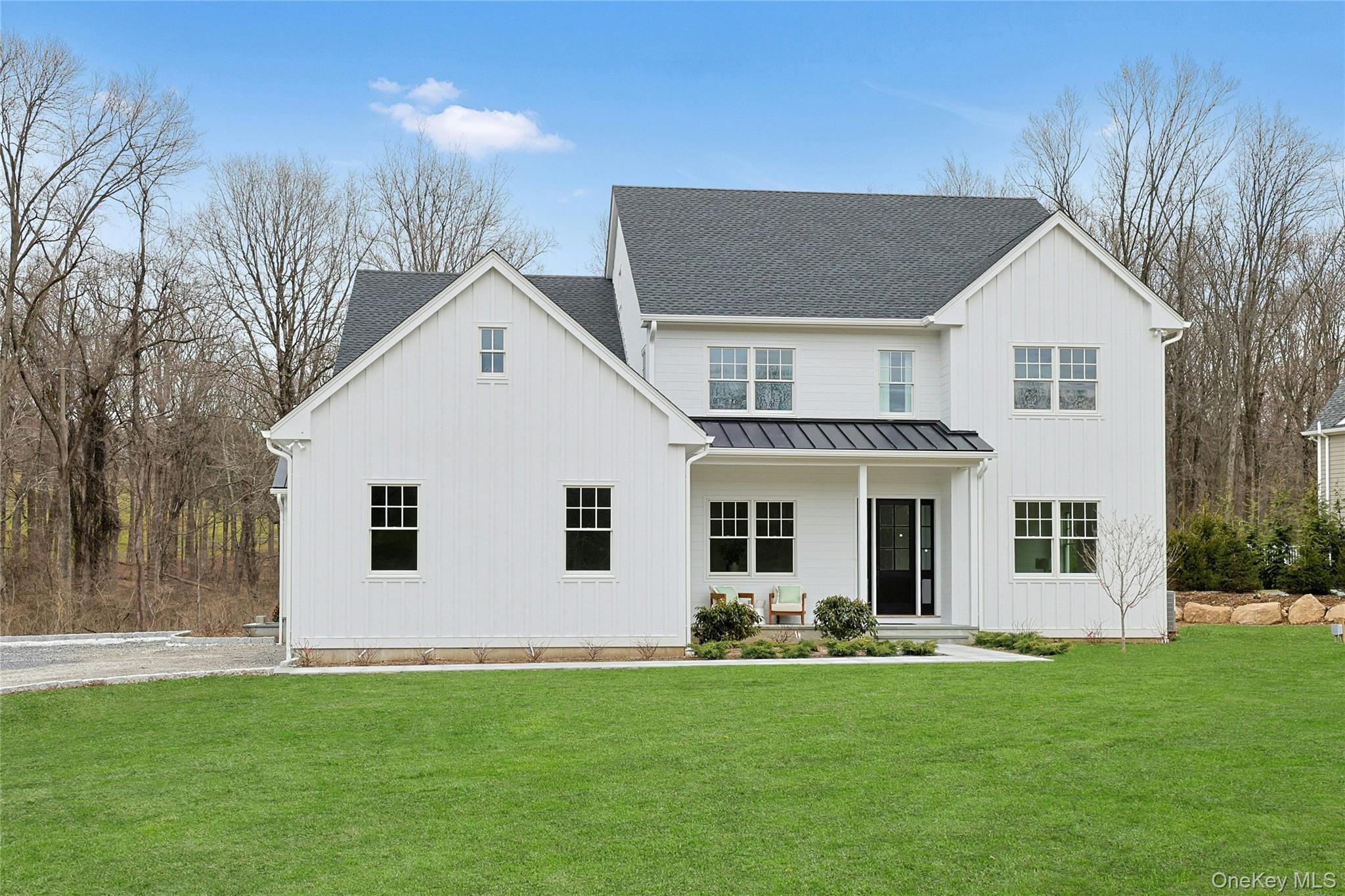 86 Old Byram Lake Road Armonk, NY 10504 - Photo 3 of 44 a view of a white house with a big yard with large windows