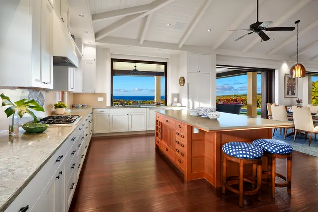 a kitchen with stainless steel appliances granite countertop a stove a sink dishwasher a microwave oven with a dining table and chairs