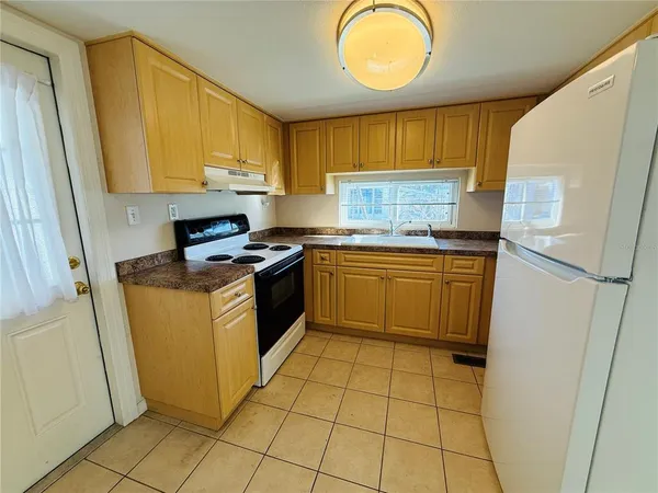 a kitchen with a sink a stove top oven a refrigerator and cabinets