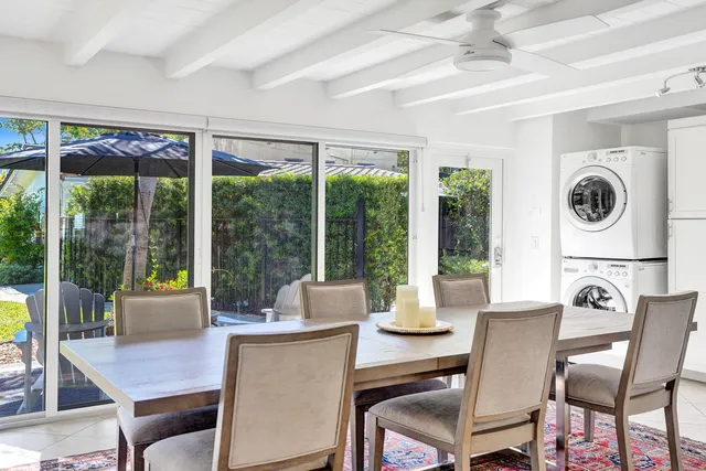 a dining room with furniture large windows and a chandelier