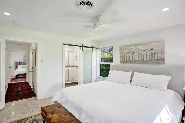 a bedroom with a large bed and a chandelier