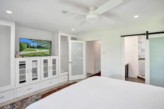 a bedroom with a bed and a large window