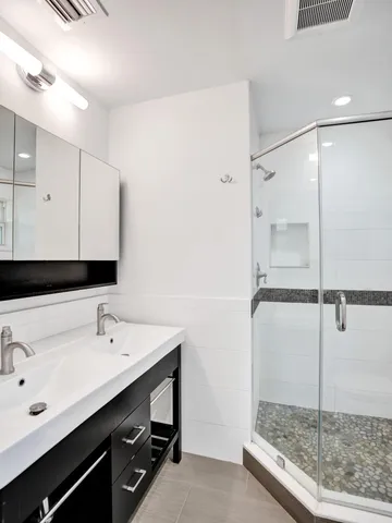 a bathroom with a shower sink and mirror