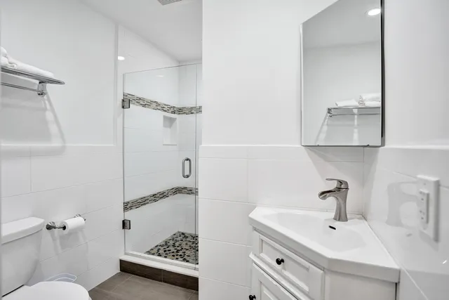 a bathroom with a sink a toilet and shower