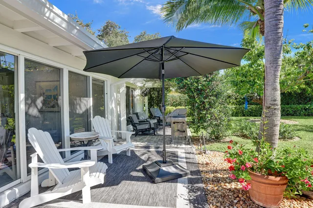 a view of a patio with chairs and potted plants
