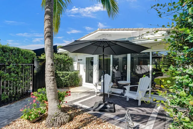 a view of a patio with chairs and potted plants
