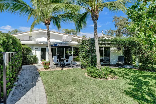 a view of a chair and tables in the backyard of a house