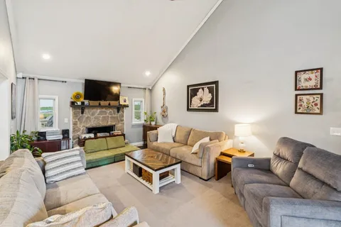 a living room with furniture a flat screen tv and a fireplace