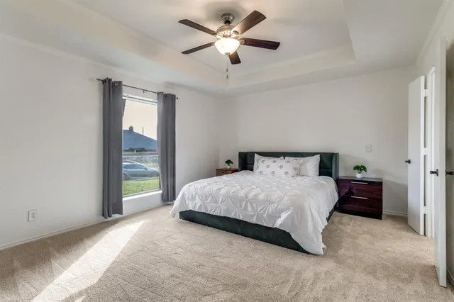 a spacious bedroom with a bed and a ceiling fan