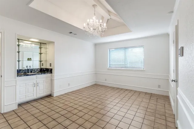 a big room with chandelier fan and windows