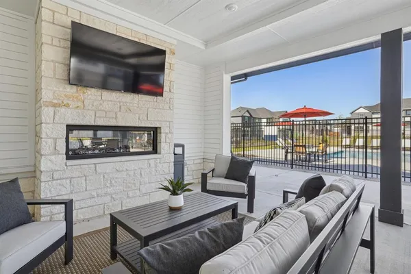a living room with furniture a flat screen tv and a fireplace